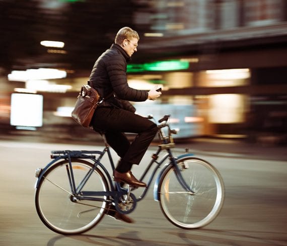 Photo of a man riding a bike in an urban setting