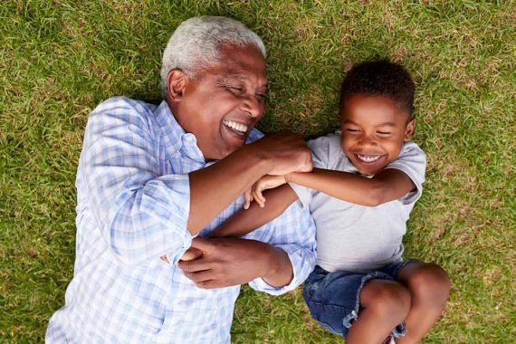 Photo of a grandfather laughing with his grandson